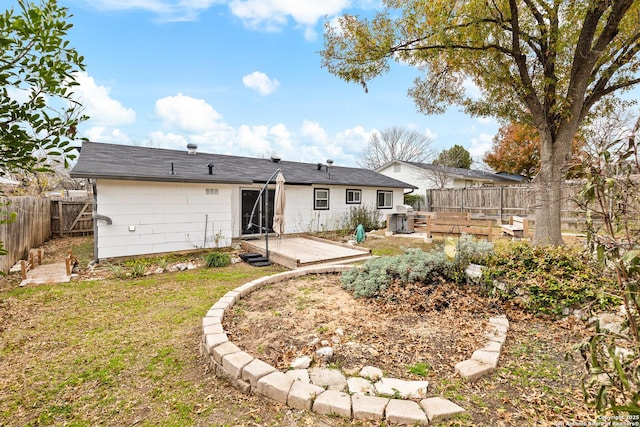 rear view of house with a yard and a wooden deck