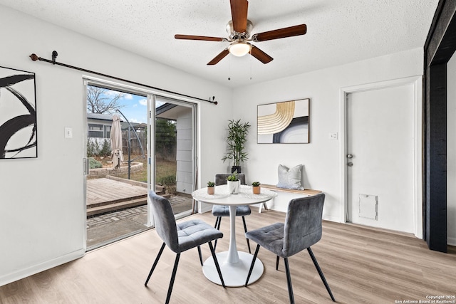 dining room with a textured ceiling, ceiling fan, and light hardwood / wood-style floors