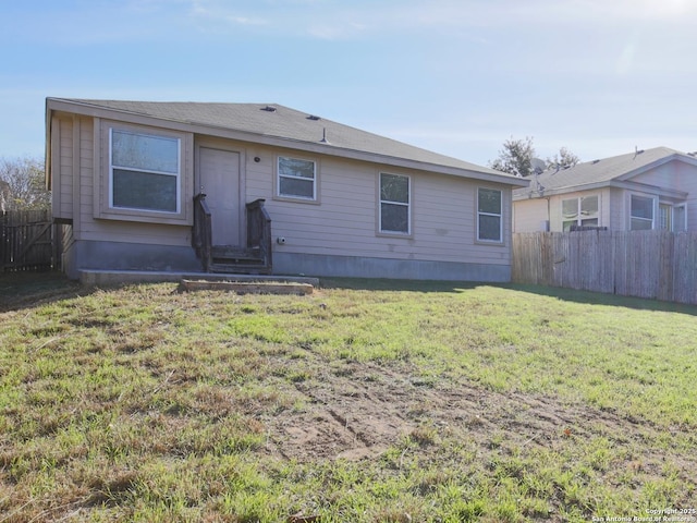 rear view of house featuring a yard