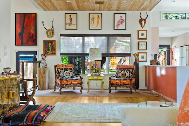 sitting room featuring light wood-type flooring and wooden ceiling