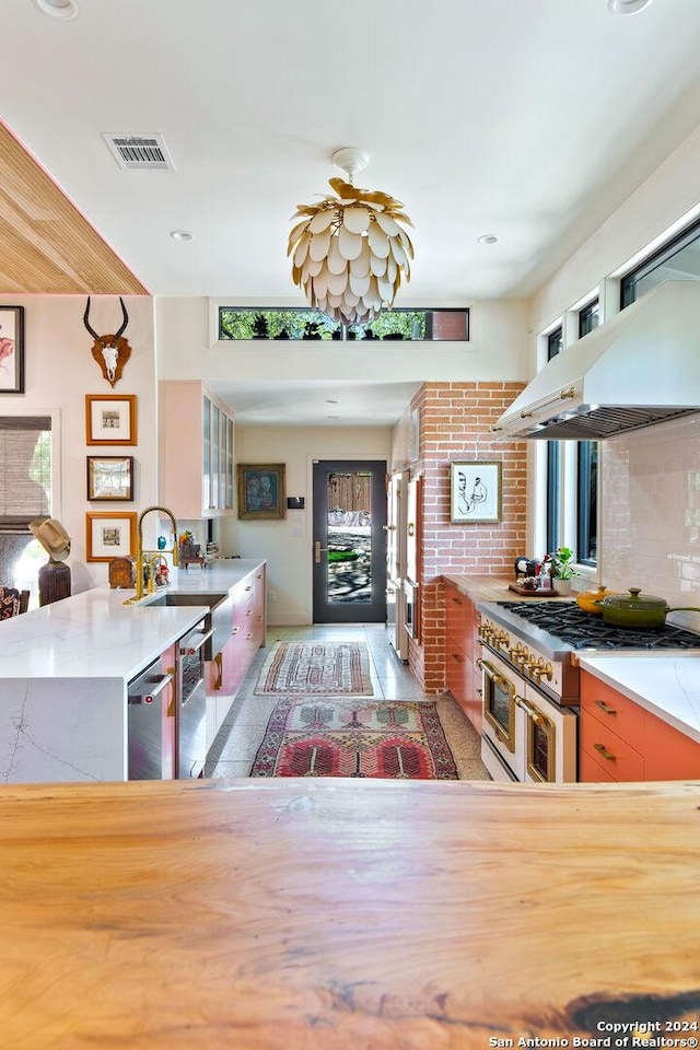 kitchen featuring appliances with stainless steel finishes, plenty of natural light, tasteful backsplash, and sink