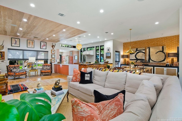 living room with brick wall, wooden ceiling, and light hardwood / wood-style floors