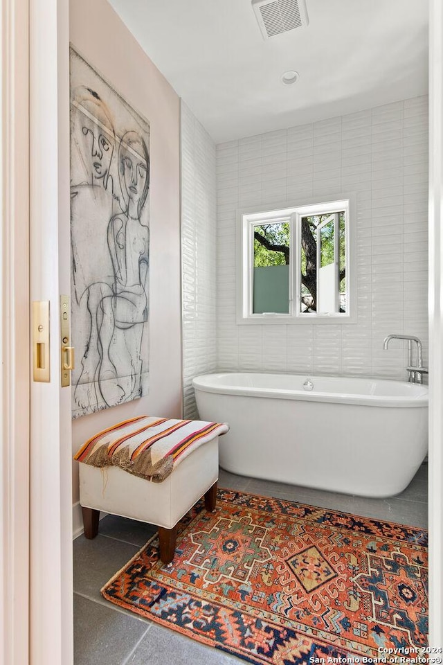 bathroom with tile walls and a tub