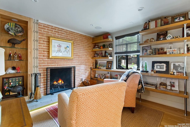 living room with a brick fireplace and light hardwood / wood-style floors