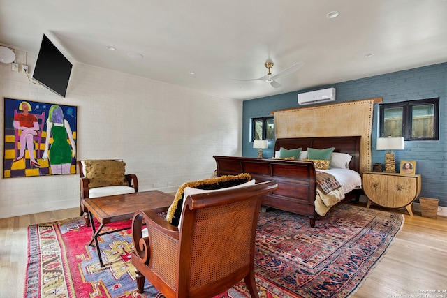 bedroom featuring an AC wall unit, brick wall, light wood-type flooring, and ceiling fan