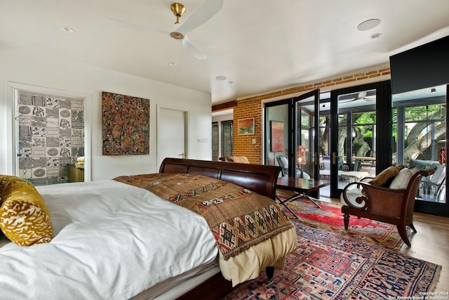 bedroom with wood-type flooring, brick wall, ceiling fan, french doors, and access to exterior