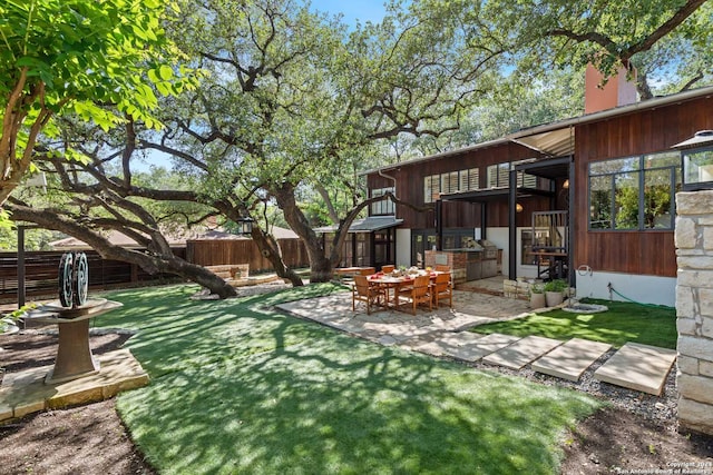 view of yard featuring exterior kitchen and a patio