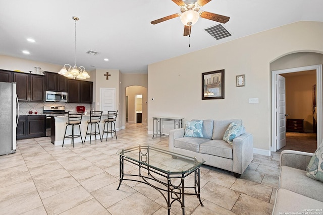 living room featuring ceiling fan with notable chandelier and lofted ceiling