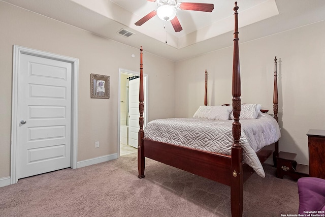 bedroom featuring ceiling fan, light colored carpet, and connected bathroom