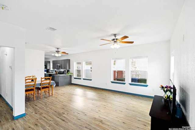 living room featuring ceiling fan, light hardwood / wood-style flooring, and plenty of natural light