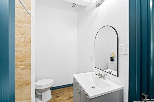 bathroom featuring hardwood / wood-style floors, vanity, and toilet