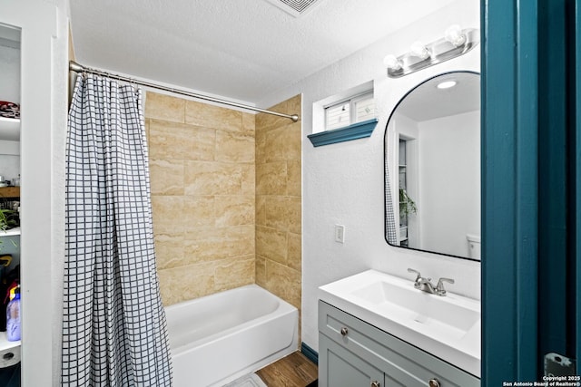 bathroom featuring a textured ceiling, shower / tub combo, and vanity