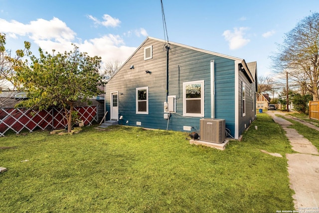 back of property featuring cooling unit and a yard