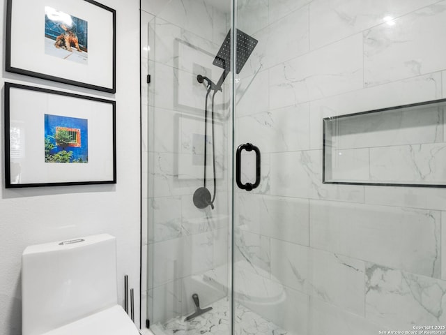 bathroom with toilet and a shower with door