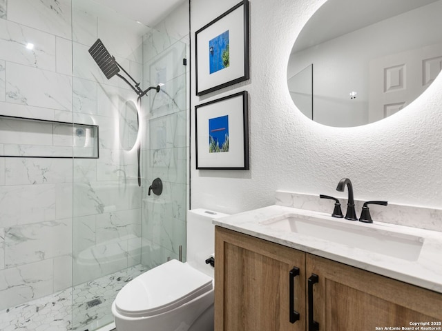 bathroom with toilet, a tile shower, and vanity