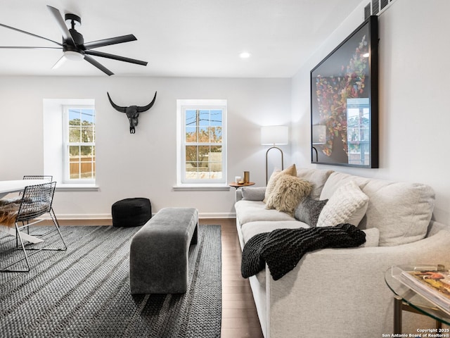 living room featuring ceiling fan and dark hardwood / wood-style floors