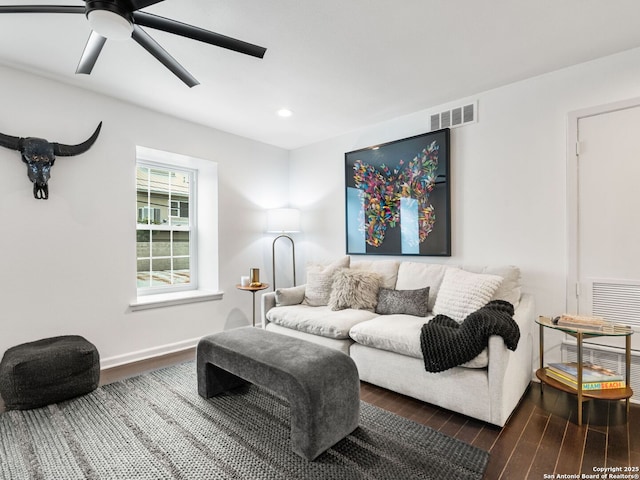 living room featuring ceiling fan and dark wood-type flooring