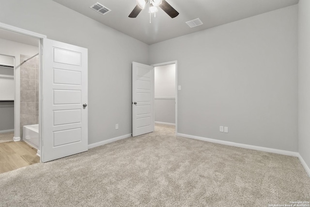 unfurnished bedroom with light colored carpet, ceiling fan, and connected bathroom