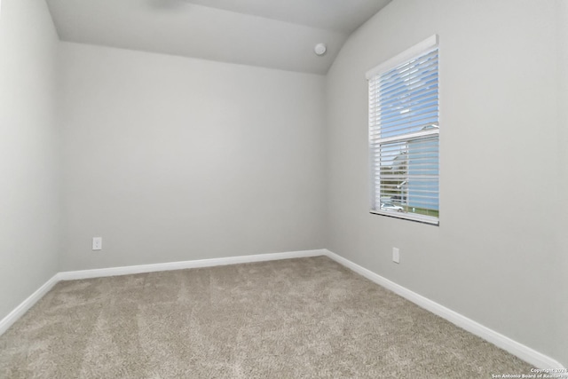 carpeted empty room with lofted ceiling