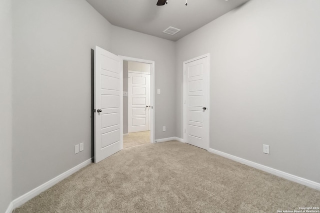 unfurnished bedroom featuring ceiling fan and light carpet