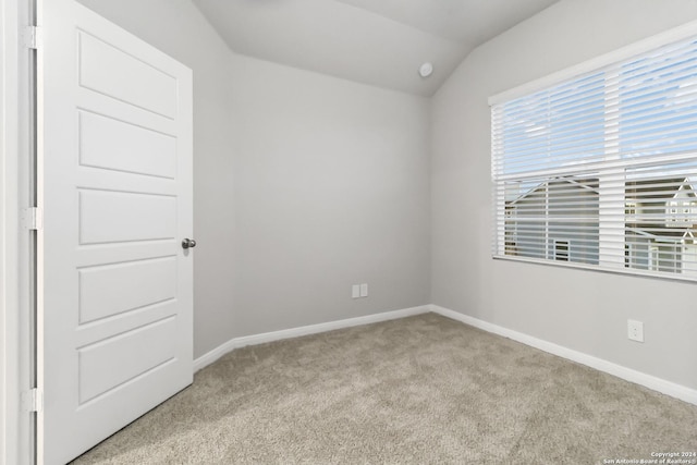 empty room with light carpet and vaulted ceiling