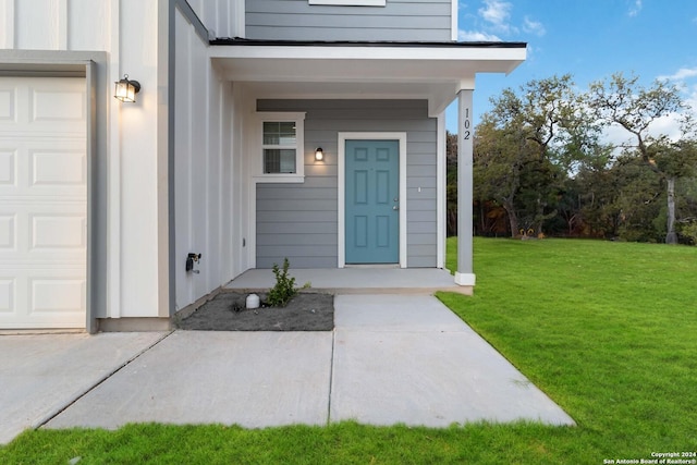 doorway to property with a lawn and a garage