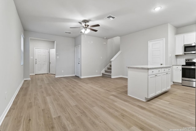 kitchen featuring stainless steel appliances, white cabinets, decorative backsplash, and ceiling fan