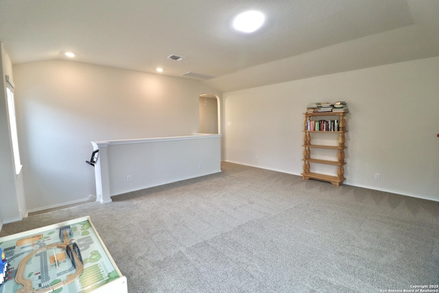 carpeted spare room with vaulted ceiling