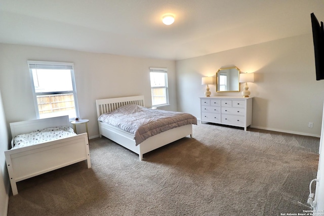 bedroom with multiple windows and dark colored carpet