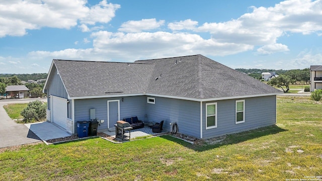 rear view of house featuring a patio, outdoor lounge area, a garage, and a lawn