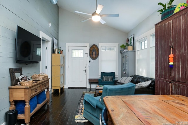 living room featuring ceiling fan, dark hardwood / wood-style flooring, wooden walls, and high vaulted ceiling