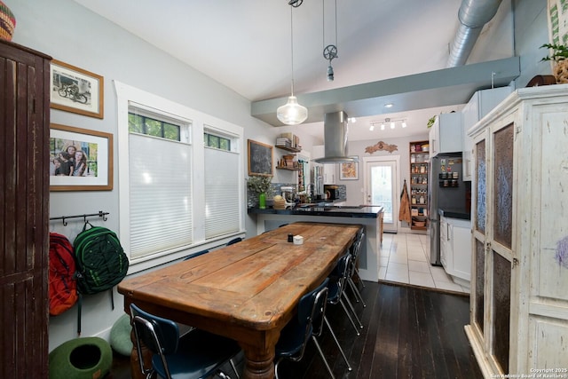 dining space with rail lighting and hardwood / wood-style flooring