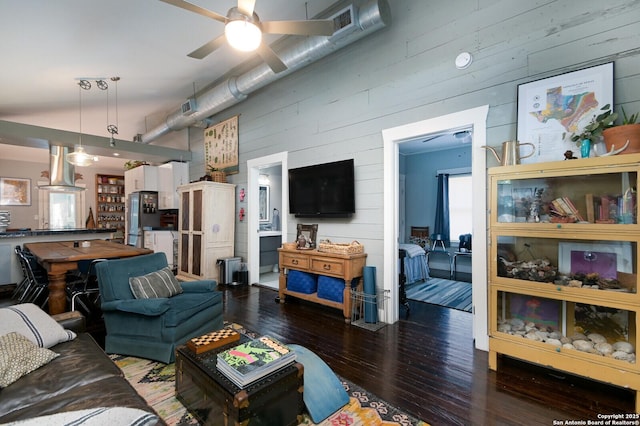 living room featuring wood walls, ceiling fan, and dark wood-type flooring