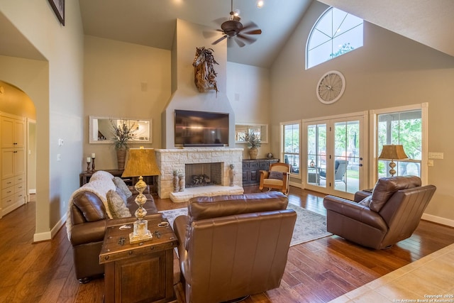 living room with wood-type flooring, a fireplace, ceiling fan, and a wealth of natural light