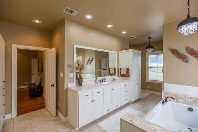 bathroom featuring a washtub, tile patterned floors, and vanity