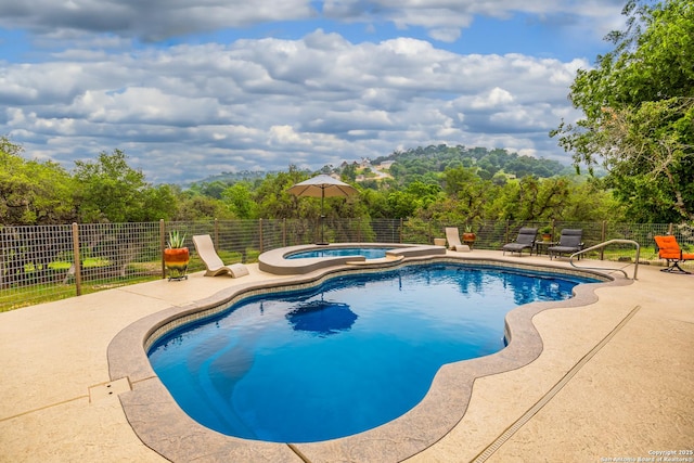 view of swimming pool featuring a patio area and an in ground hot tub