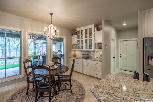 tiled dining room featuring a notable chandelier