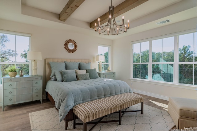 bedroom featuring a chandelier, light wood-type flooring, and beam ceiling