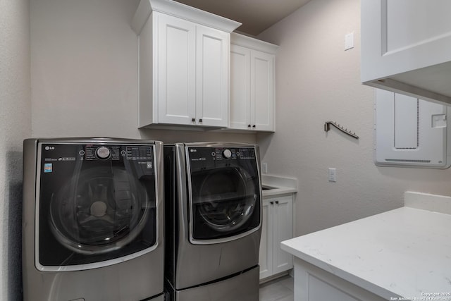 washroom featuring cabinets and independent washer and dryer