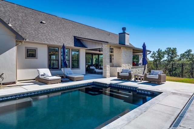 back of house featuring a fenced in pool, ceiling fan, outdoor lounge area, and a patio