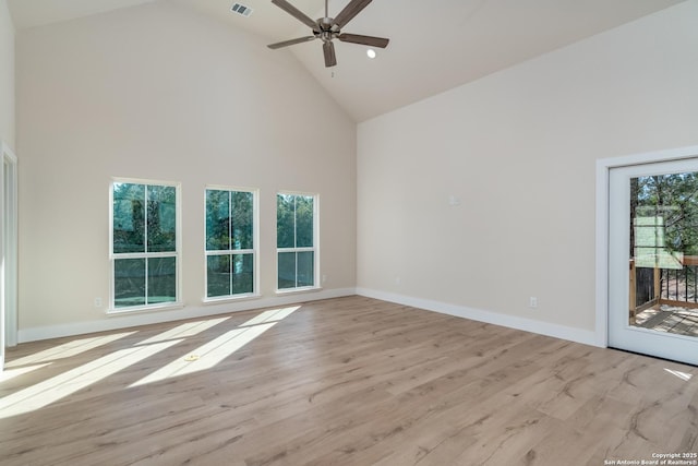 unfurnished room with a healthy amount of sunlight, light hardwood / wood-style flooring, and high vaulted ceiling