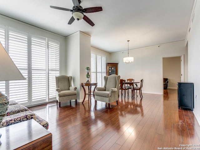 living room with ceiling fan with notable chandelier and dark wood-type flooring