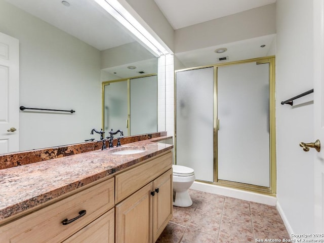 bathroom featuring toilet, a shower with door, and vanity