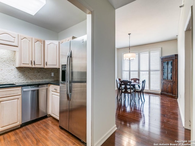 kitchen featuring stainless steel appliances, tasteful backsplash, hanging light fixtures, dark hardwood / wood-style flooring, and a notable chandelier