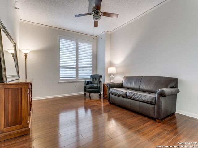 sitting room featuring dark wood-type flooring, a textured ceiling, ceiling fan, and crown molding