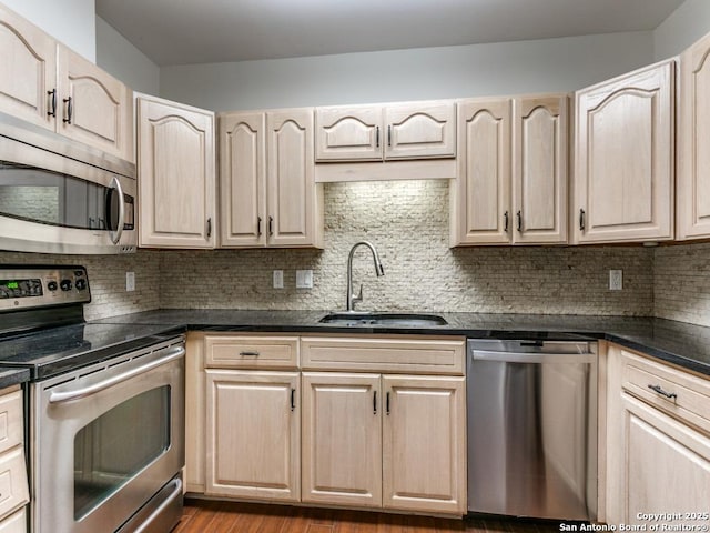 kitchen featuring sink, stainless steel appliances, backsplash, and light brown cabinets