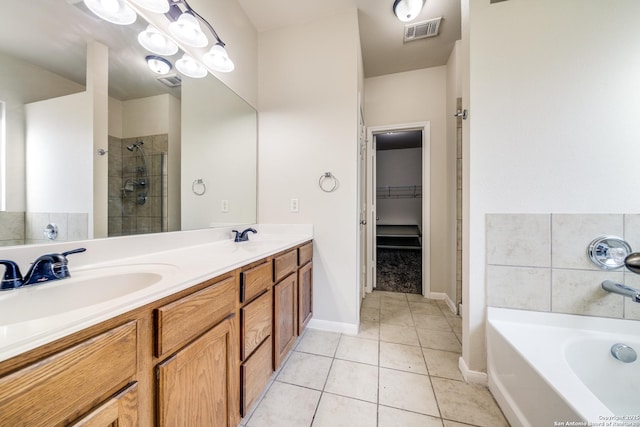 bathroom featuring vanity, shower with separate bathtub, and tile patterned flooring