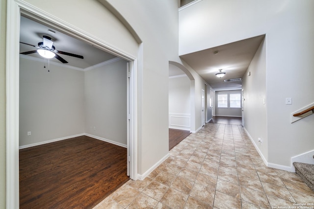 hallway with ornamental molding and light tile patterned floors