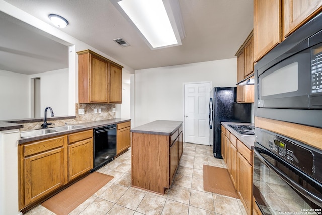 kitchen with a center island, black appliances, decorative backsplash, light tile patterned flooring, and sink