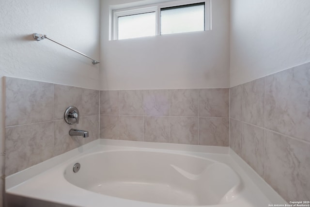 bathroom with a washtub and plenty of natural light